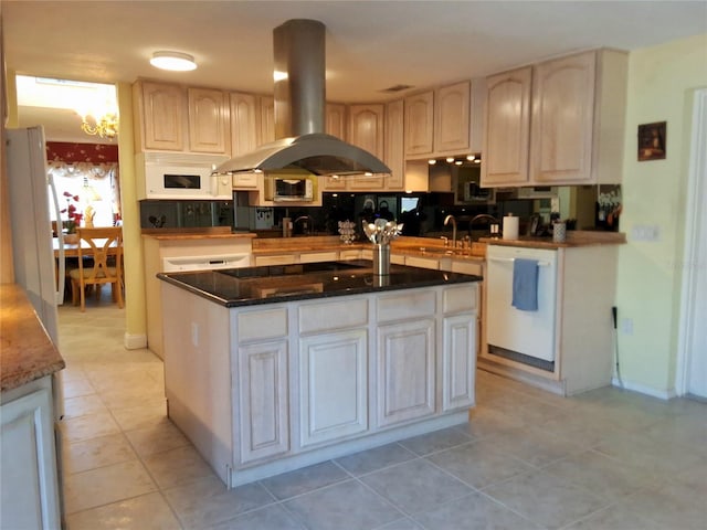 kitchen with white appliances, a center island, island exhaust hood, a sink, and light tile patterned flooring