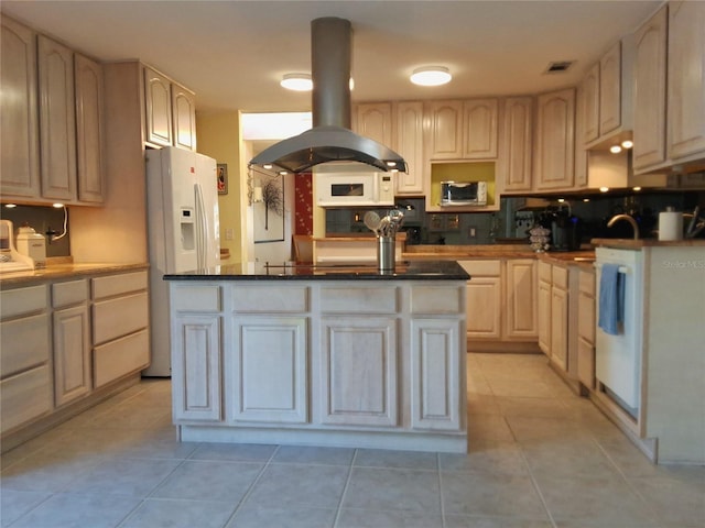 kitchen featuring light tile patterned floors, a kitchen island, a sink, island range hood, and white appliances