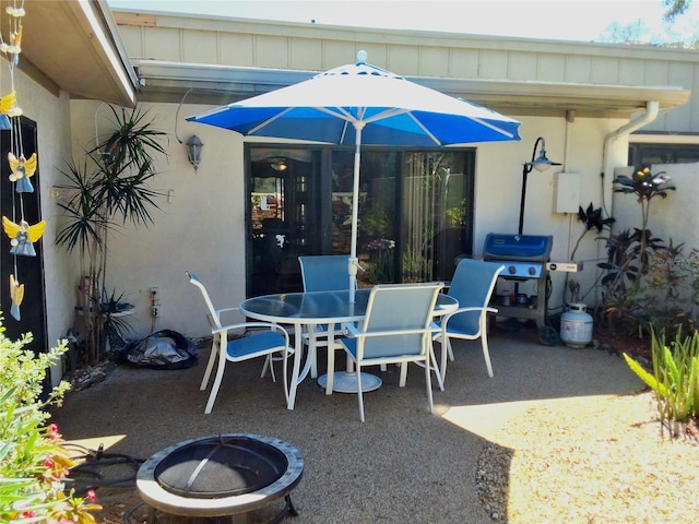 view of patio featuring an outdoor fire pit, outdoor dining area, and area for grilling