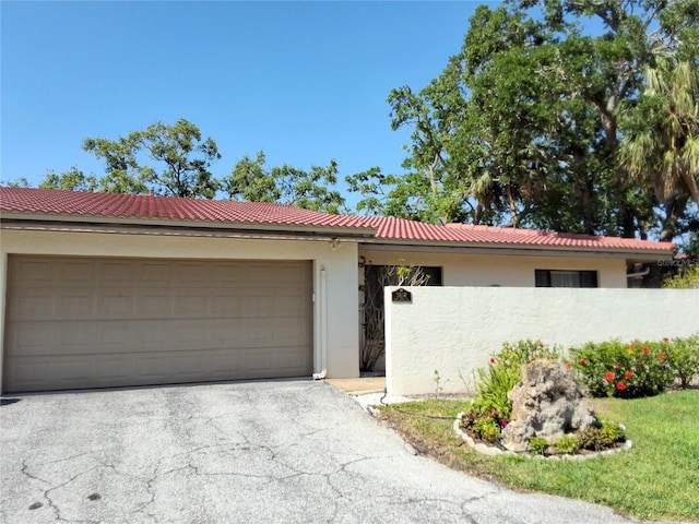 3818 Sun Eagle Ln, Bradenton, FL 34210 - view of front of home featuring stucco siding, aphalt driveway, a tile roof, a garage, and fence