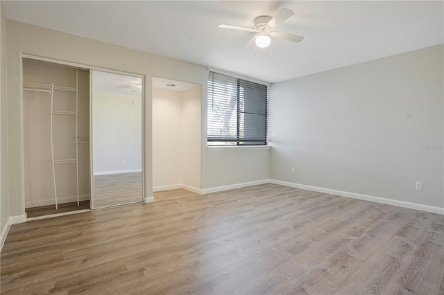 unfurnished bedroom featuring a closet, baseboards, and wood finished floors