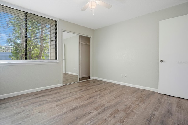 unfurnished bedroom featuring ceiling fan, a closet, wood finished floors, and baseboards