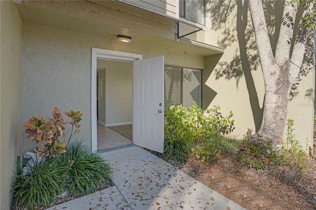 doorway to property featuring stucco siding