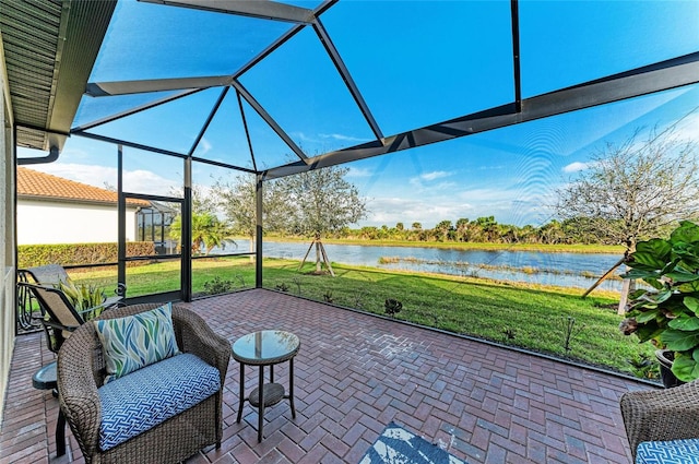 view of patio / terrace featuring glass enclosure and a water view