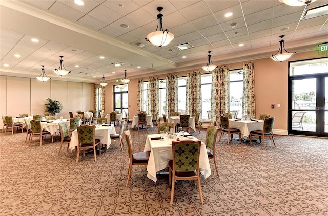 dining area with ornamental molding, french doors, plenty of natural light, and a raised ceiling