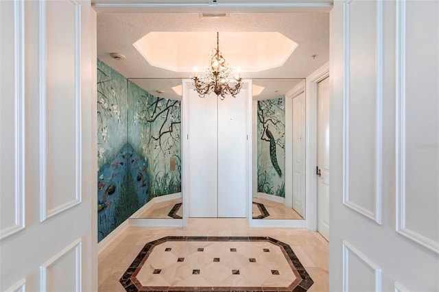 interior space featuring a tray ceiling, baseboards, and wallpapered walls