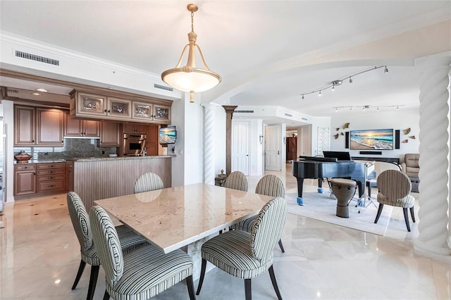 dining room featuring crown molding, visible vents, and ornate columns