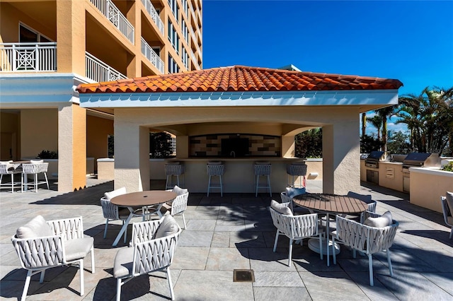 view of patio featuring outdoor dry bar, area for grilling, a grill, and outdoor dining area