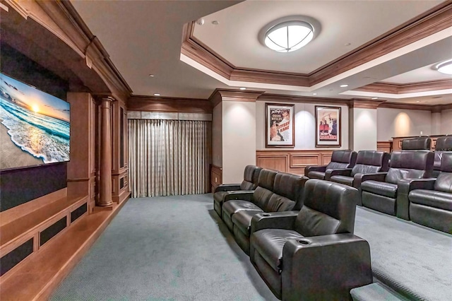 carpeted home theater room with a decorative wall, a raised ceiling, wainscoting, and ornate columns