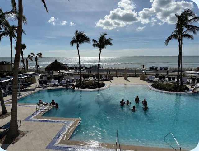 pool featuring a water view and a patio area