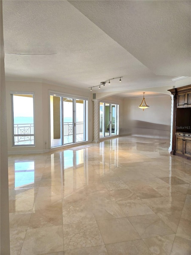 35 Watergate Dr Unit 1103, Sarasota, FL 34236 - spare room with healthy amount of natural light, a textured ceiling, crown molding, and light marble finish floors