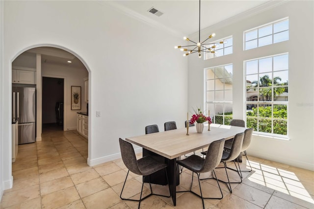 dining room with arched walkways, ornamental molding, visible vents, and baseboards