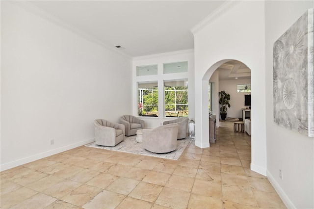 sitting room featuring baseboards, arched walkways, visible vents, and crown molding