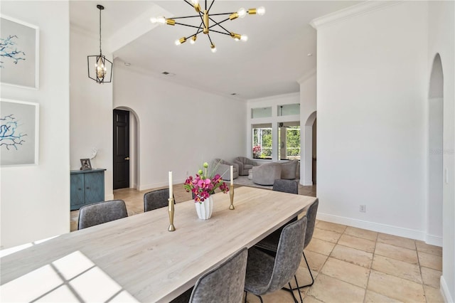 dining area featuring arched walkways, crown molding, a notable chandelier, and baseboards