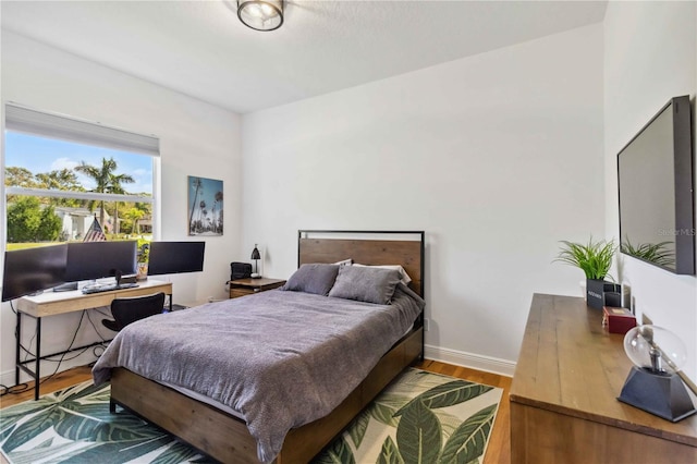 bedroom with baseboards and wood finished floors