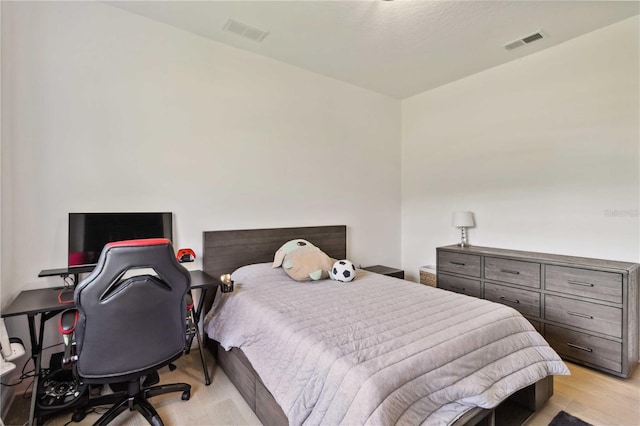 bedroom featuring light wood-style floors and visible vents