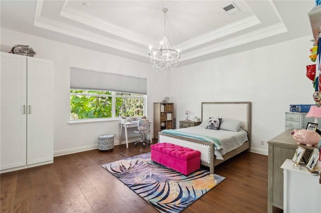 bedroom featuring a raised ceiling, visible vents, a notable chandelier, and wood finished floors