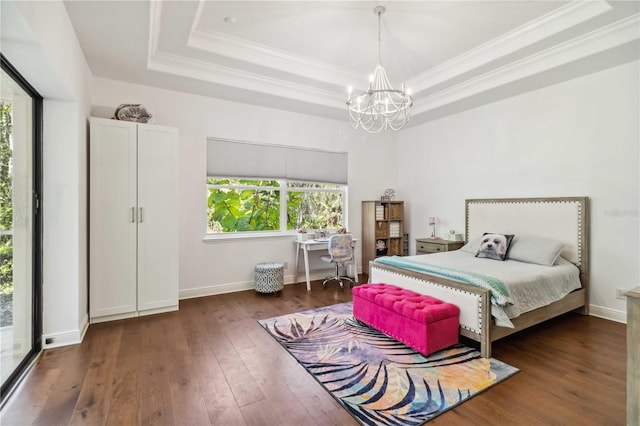 bedroom with baseboards, a raised ceiling, wood-type flooring, ornamental molding, and an inviting chandelier