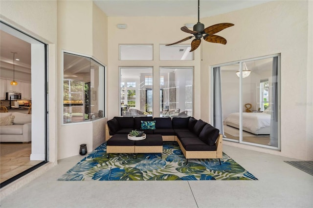 carpeted living area with a ceiling fan and a towering ceiling