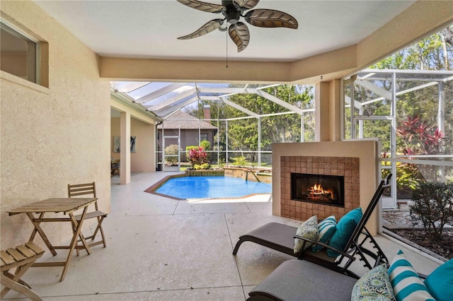 outdoor pool with a patio, a tiled fireplace, a lanai, and a ceiling fan