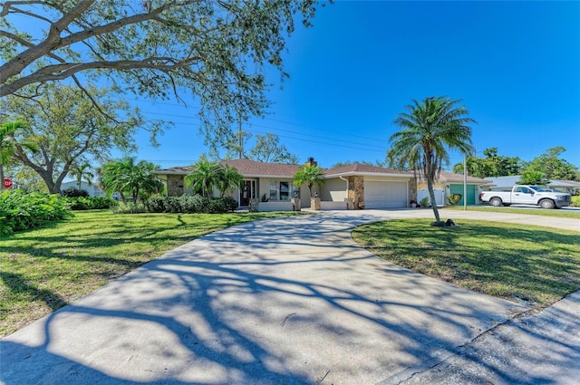 ranch-style house with a garage, curved driveway, a front lawn, and stucco siding