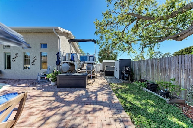 view of patio featuring an outbuilding, a grill, a fenced backyard, and a storage shed