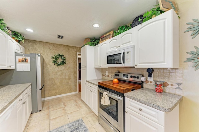 kitchen featuring visible vents, light countertops, stainless steel appliances, light tile patterned flooring, and white cabinetry