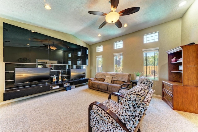 living room with ceiling fan, carpet floors, and a textured ceiling