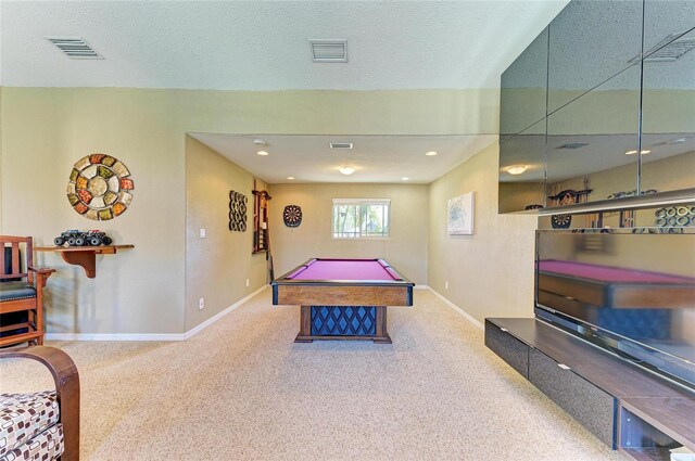 recreation room with carpet flooring, baseboards, visible vents, and a textured ceiling