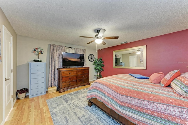 bedroom featuring ceiling fan, a textured ceiling, and wood finished floors