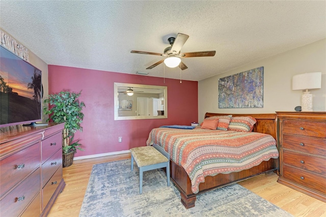 bedroom with visible vents, a textured ceiling, and light wood-style floors