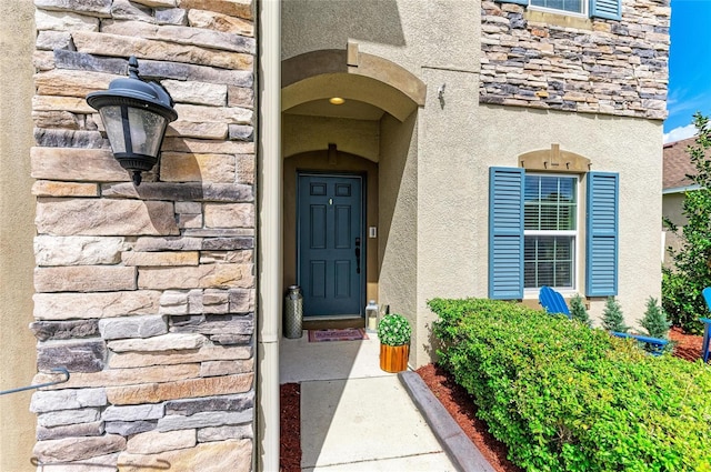 entrance to property with stone siding and stucco siding