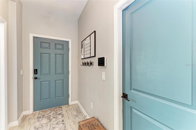 entryway featuring baseboards and wood finished floors