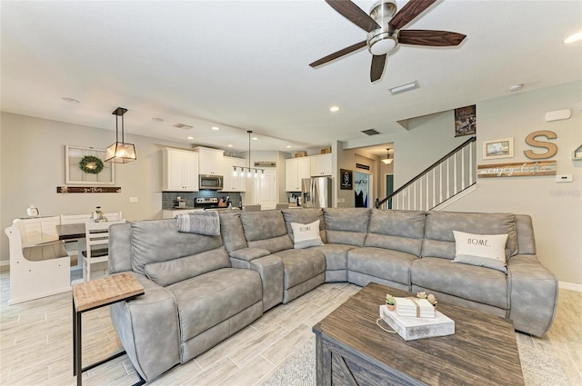 living area featuring recessed lighting, wood finish floors, visible vents, baseboards, and stairs