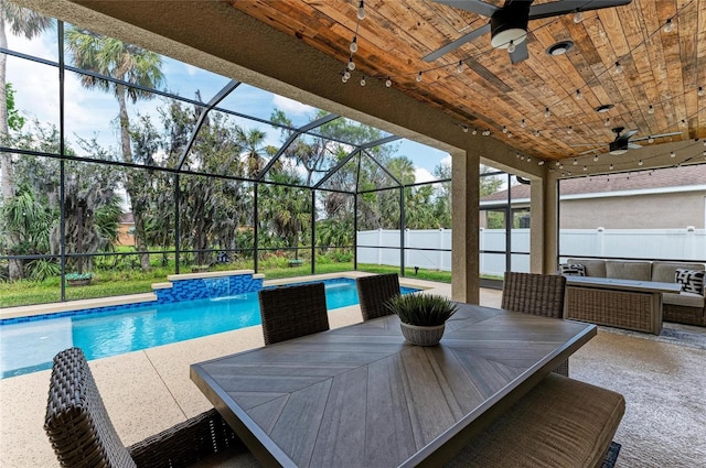 outdoor pool with glass enclosure, outdoor dining area, a patio area, and a fenced backyard