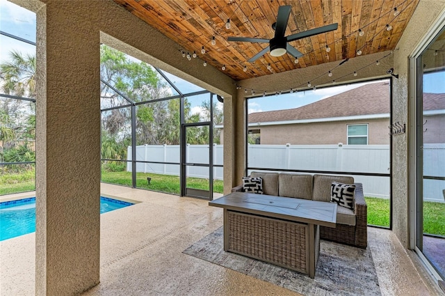 sunroom / solarium with a ceiling fan and wooden ceiling