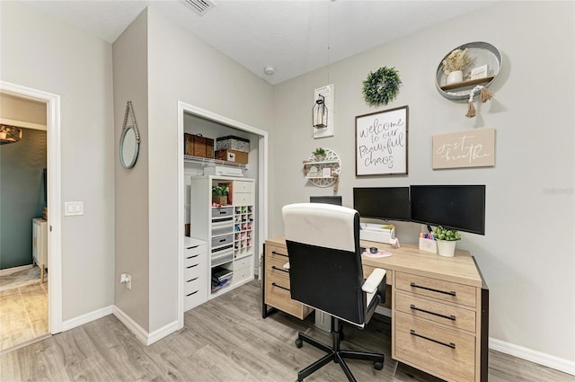 home office with baseboards and light wood finished floors