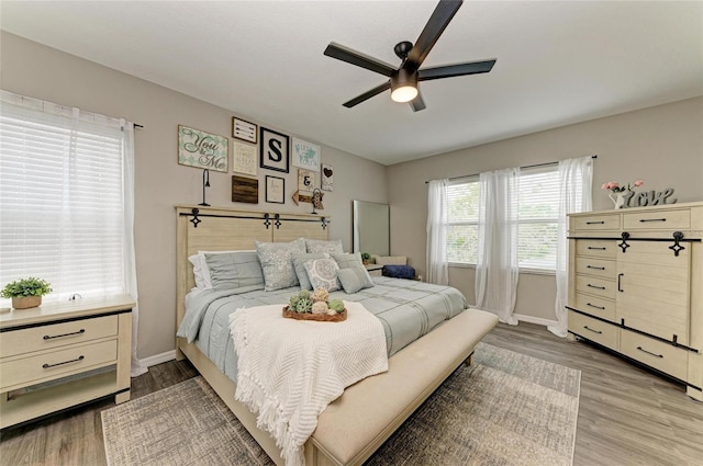 bedroom with ceiling fan, baseboards, and wood finished floors