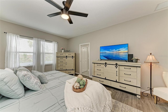 bedroom with baseboards, light wood finished floors, visible vents, and a ceiling fan