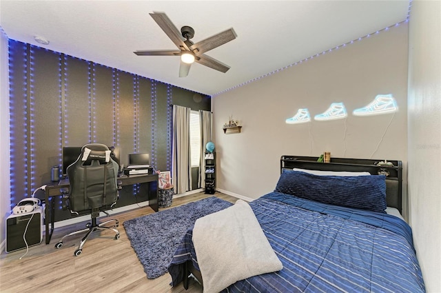 bedroom with wood finished floors, a ceiling fan, and baseboards