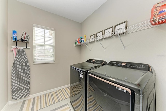 laundry room featuring laundry area, baseboards, and washing machine and clothes dryer