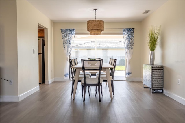 dining room with wood finished floors, visible vents, and baseboards