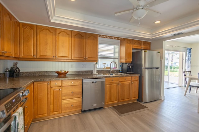 kitchen featuring appliances with stainless steel finishes, brown cabinets, and a sink