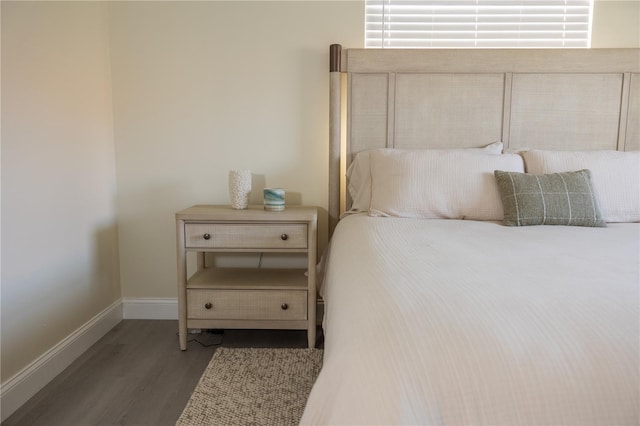 bedroom featuring baseboards and wood finished floors