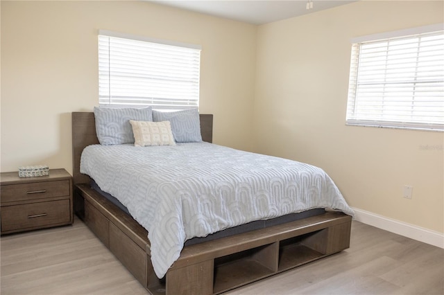 bedroom with light wood-style flooring and baseboards