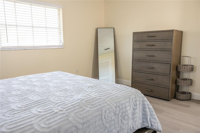 bedroom with light wood-style floors and baseboards