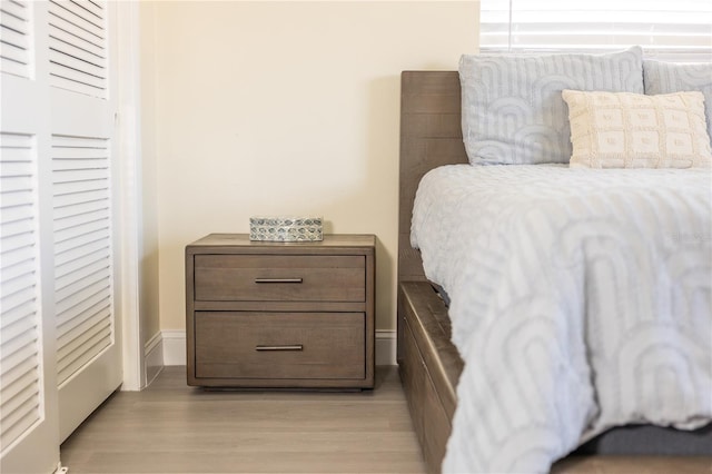 bedroom with light wood finished floors and a closet