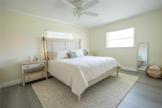 bedroom featuring light wood finished floors, baseboards, and a ceiling fan