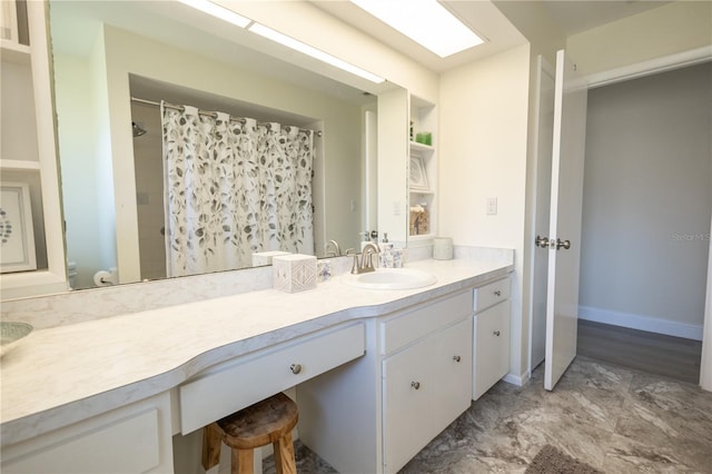 bathroom featuring curtained shower, baseboards, and vanity