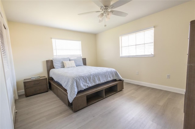 bedroom featuring light wood-style floors, baseboards, and a ceiling fan